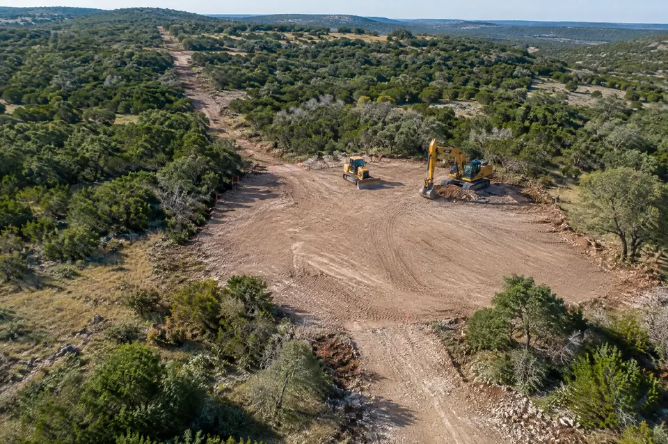 Pipeline corridor clearing: aerial view of a cleared pad site at the end of a narrow corridor through brush