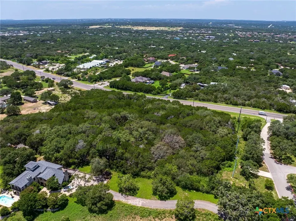 Aerial view of dense brush and trees on the Christ Our King property before clearing