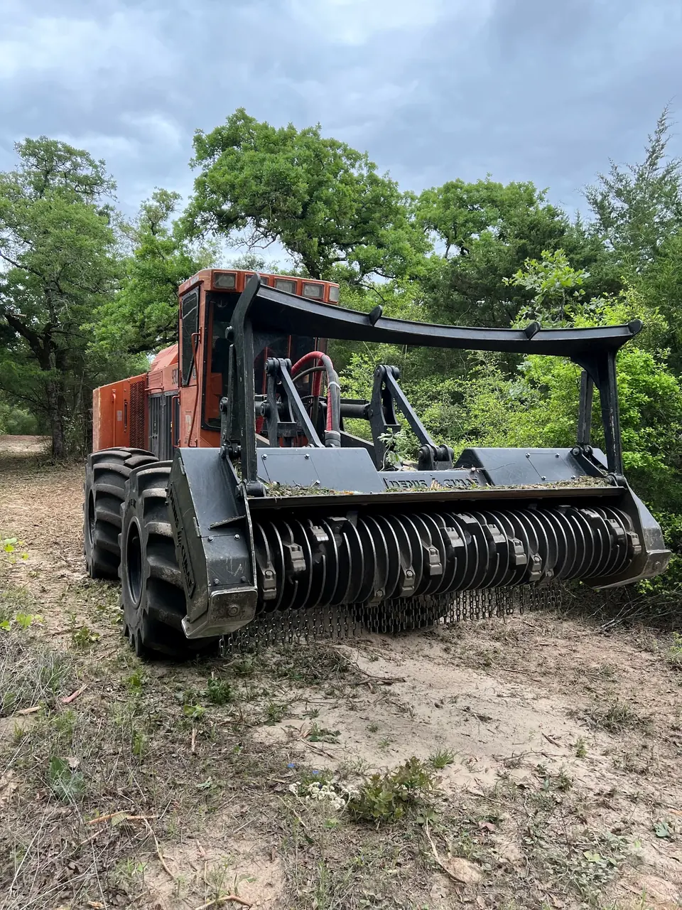 Articulated forestry mulcher with its drum head on a cleared site
