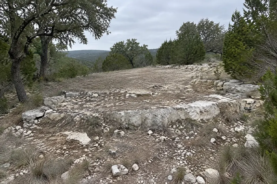Building on rocky land in Texas: cleared Hill Country home site with stair-step limestone ledges breaking through thin stony soil