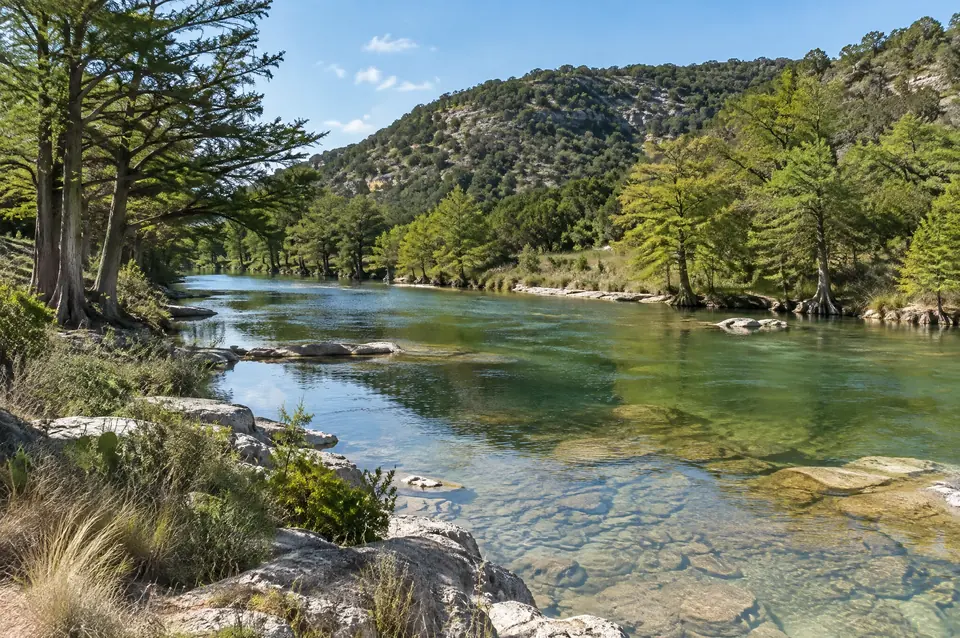 Clear Guadalupe River over a limestone bed near Kerrville, cypress on the banks