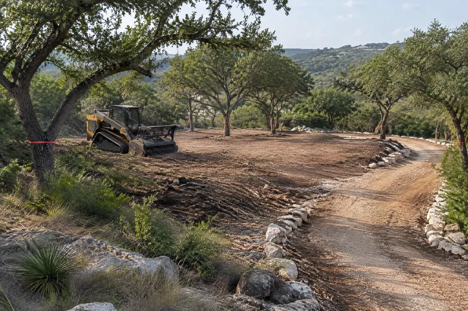 Home site clearing Boerne: cleared home site outside Boerne with kept live oaks and a curving driveway