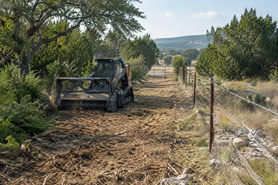 Ranch clearing: cleared lane along a barbed wire ranch fence through brush