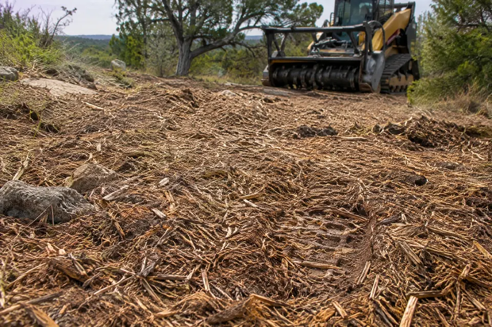 Mulching land clearing: close view of a fine toothpick-size mulch finish with a track mulcher behind