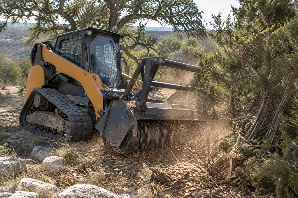 Forestry mulching in Central Texas: compact track loader mulching head grinding a stand of cedar into fine mulch
