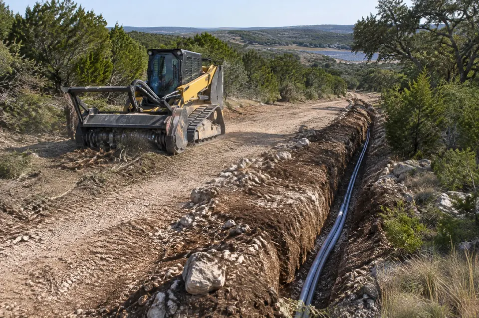 Solar site clearing: conduit trench along a new access road on a cleared solar site