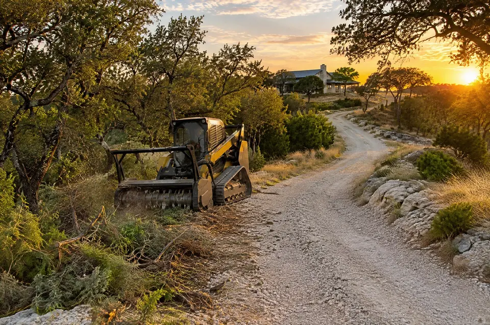 Lot clearing Kendall County: crushed limestone driveway climbing a Kendall County hillside toward a home