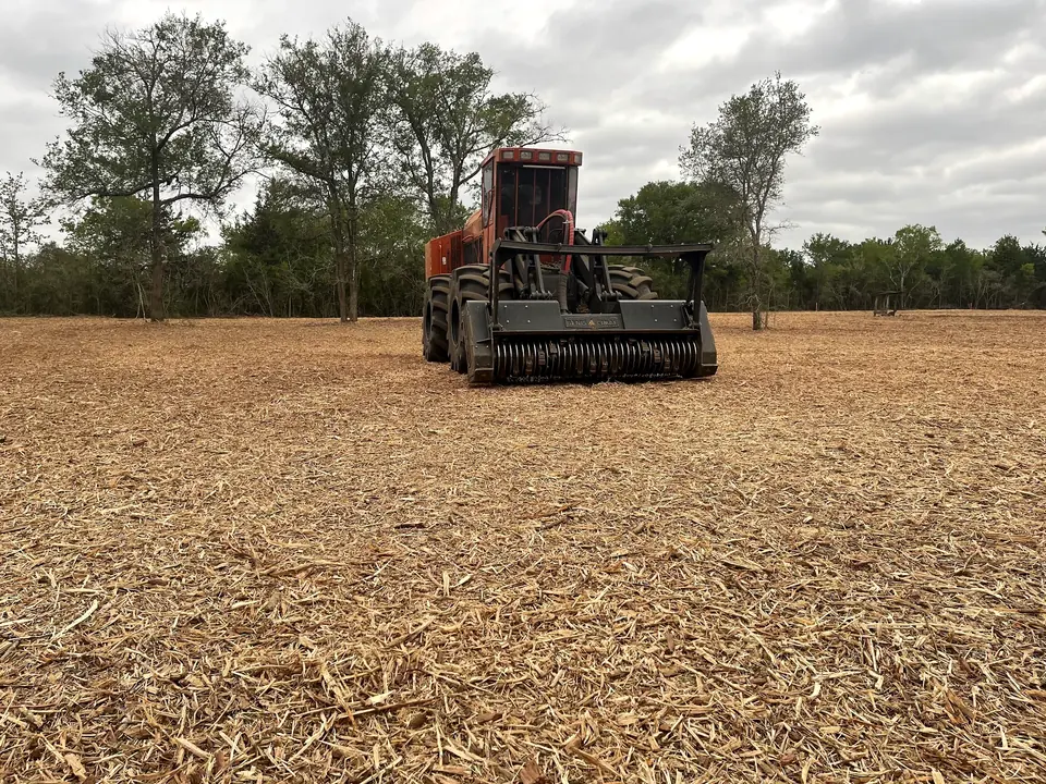 Forestry mulcher working across an open, mulched tract