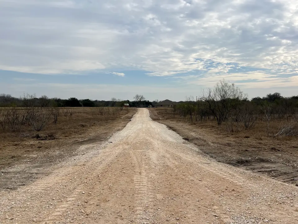 Long, straight access road built through brush
