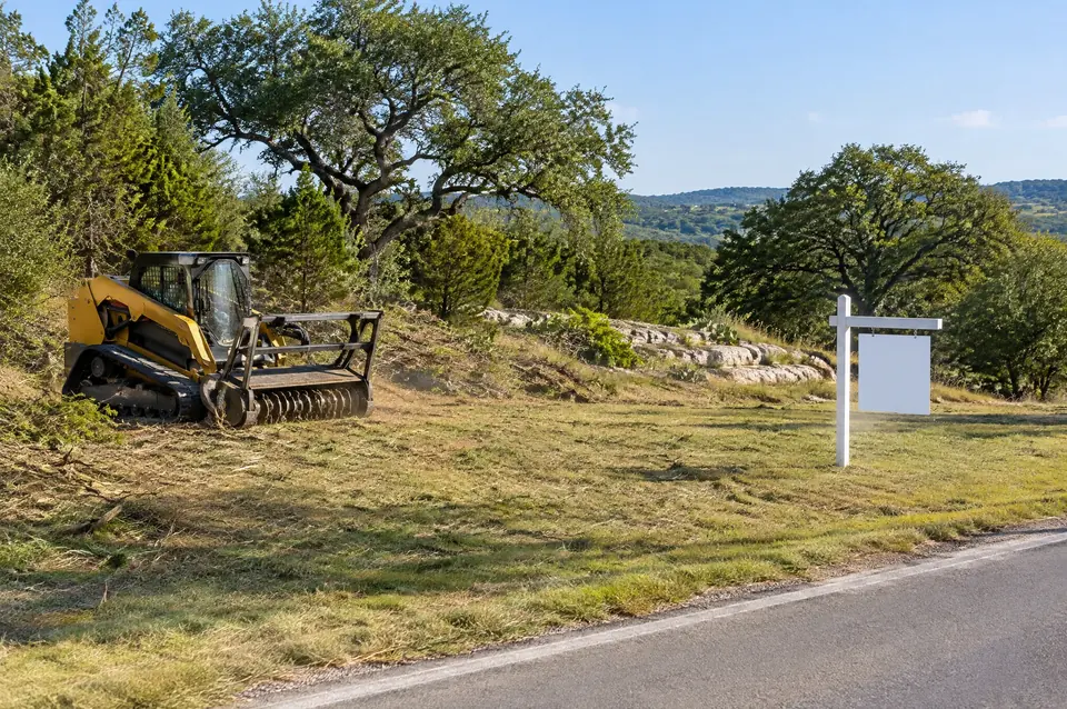 Commercial grounds maintenance: mowed commercial lot along a road frontage with a blank sign post
