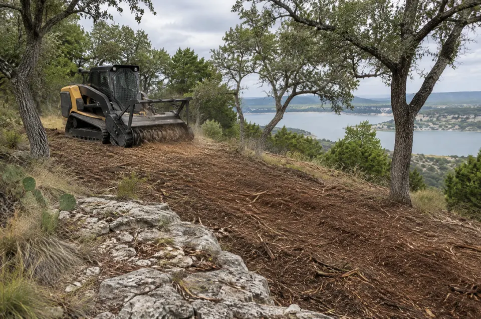 Lot clearing Canyon Lake: mulched Canyon Lake hillside over limestone ledges, live oaks kept, lake below