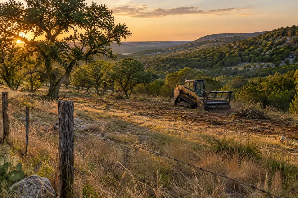 9 Arrow Land Service: ridge view of cleared grassland, kept live oaks and cedar-covered hills behind a ranch fence