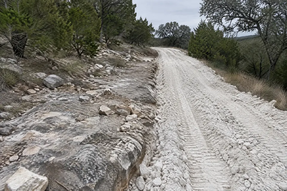 Rock crushing depth: rocky road route half crushed into a deep bed of broken limestone, half still bare ledge