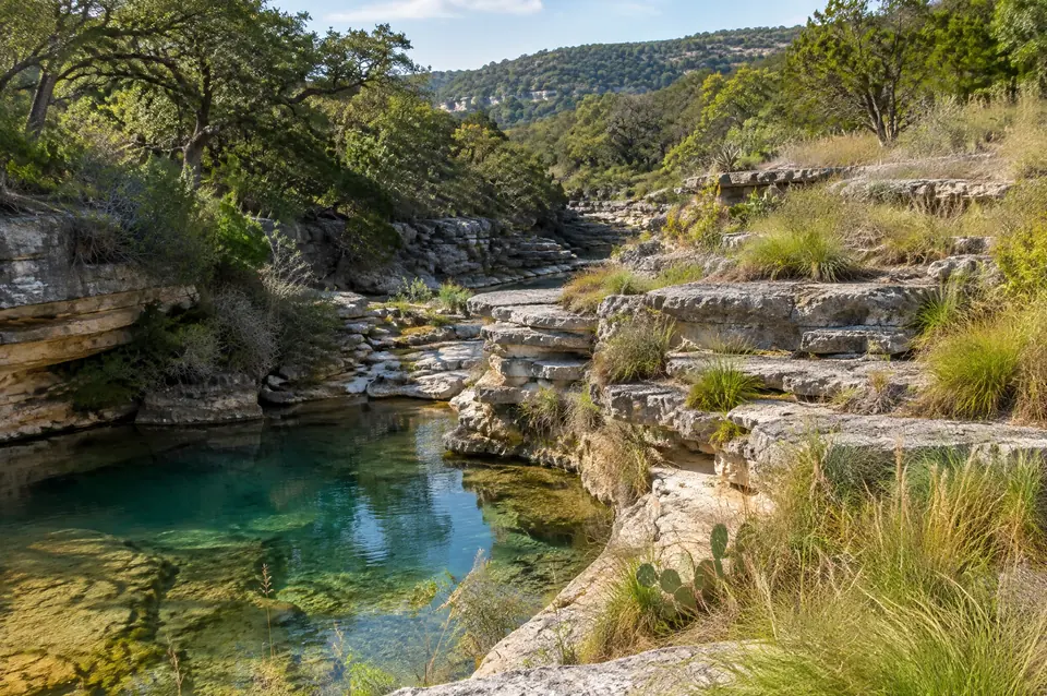 Stair-step limestone gorge with a clear pool near Canyon Lake