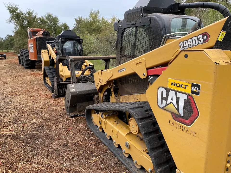 9 Arrow track loaders lined up on a job
