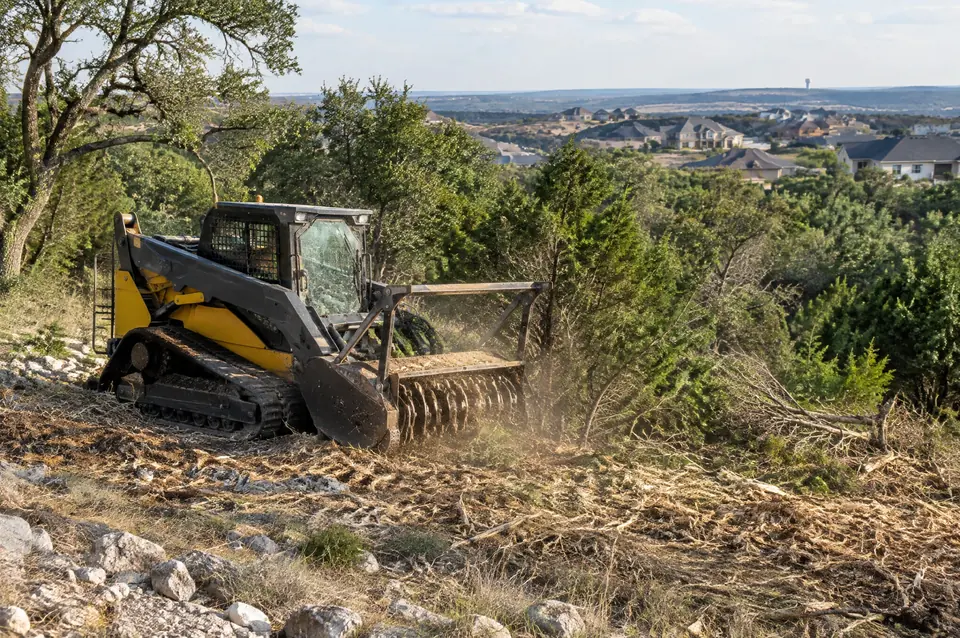Lot clearing New Braunfels: track mulcher clearing a tract on the edge of New Braunfels, new homes beyond