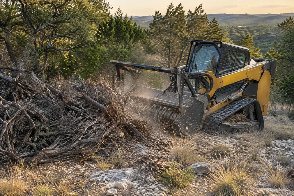 Underbrush clearing: track mulcher grinding an old pile of dead cedar brush