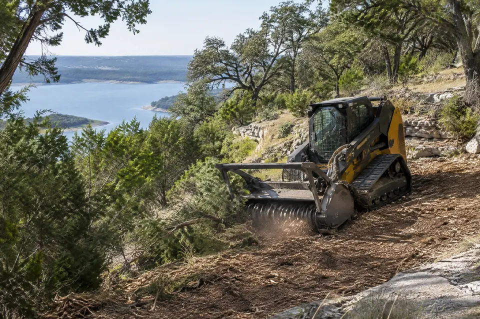 Canyon Lake lot clearing with a mulcher: track mulcher on a terraced limestone slope above Canyon Lake