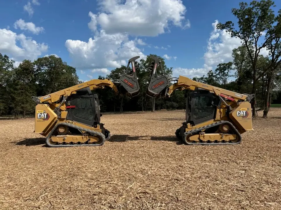 Two track loaders with mulching heads on a cleared site
